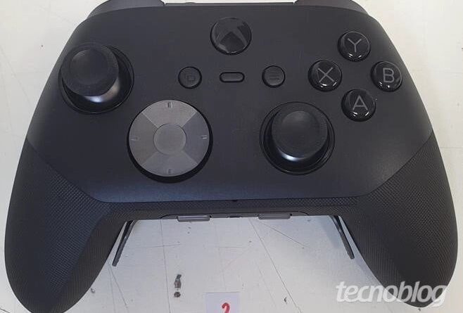 Top view of a black Xbox-like game controller with two analog sticks, D-pad, ABXY buttons, and center Xbox button; watermark TECNO BLOG visible in corner.