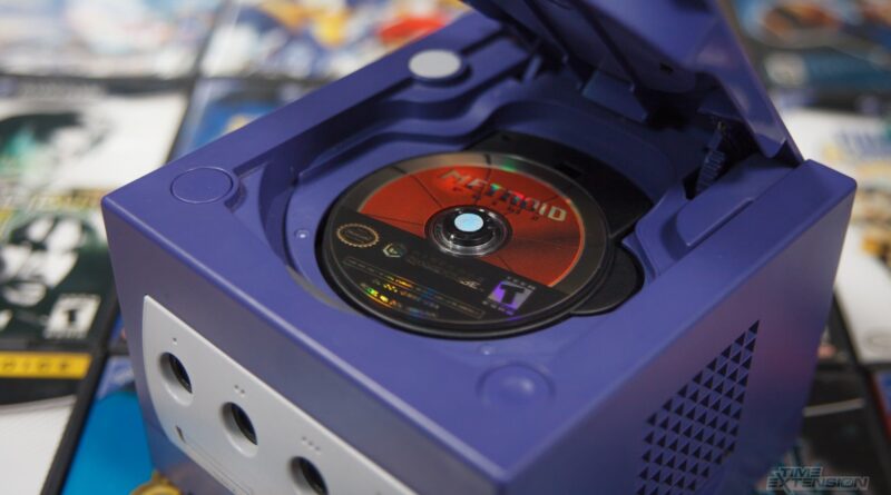 Purple Nintendo GameCube with lid open and a game disc in the tray