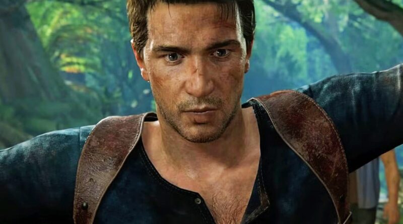 Rugged man with stubble in a dark shirt and brown leather gear, in a lush jungle, looking intently forward.