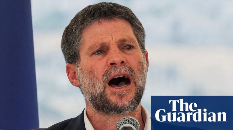 Man with a gray beard speaking into a microphone at an outdoor event, Guardian logo overlay in bottom right.