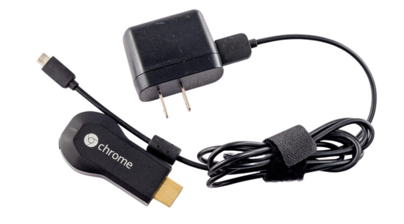 Google Chromecast streaming dongle with HDMI plug, USB power cable, and wall charger on a white background.