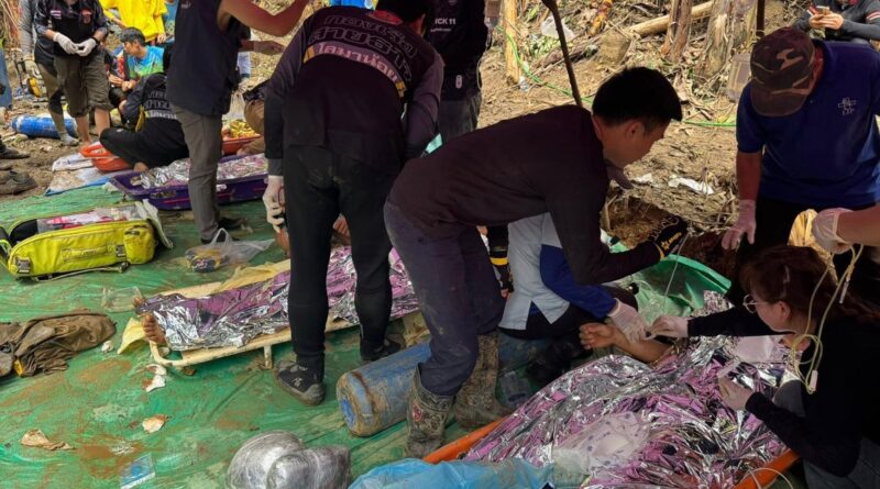 Emergency responders treating a patient on a stretcher outdoors with foil blankets and medical gear nearby.