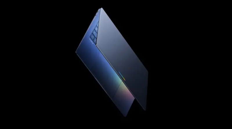 Slanted blue laptop open at a slight angle against a black background, showing the keyboard and colorful edge glow.