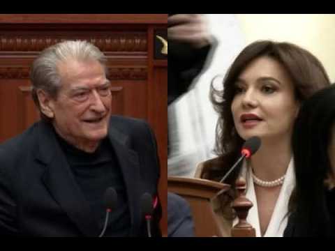 Split image: left, an older man in a dark suit smiling in a wood-paneled room; right, a woman with dark hair and a pearl necklace speaking into a microphone at a podium.
