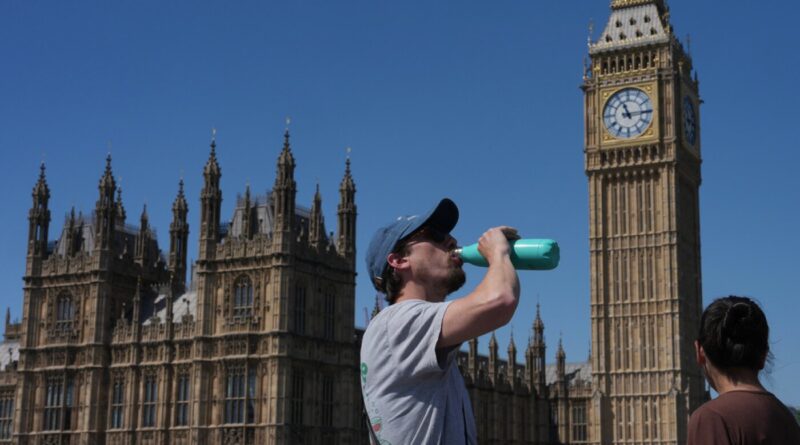 Man drinks from a turquoise water bottle near the Houses of Parliament and Big Ben on a sunny day; another person faces away in foreground.