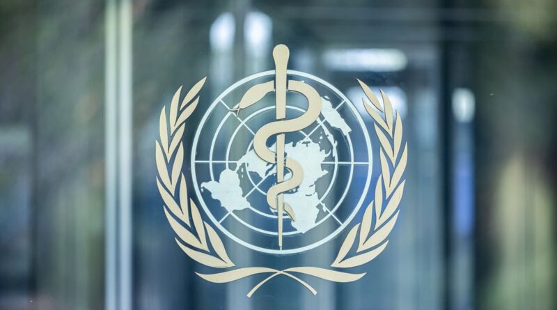 WHO emblem on a glass door: staff entwined around a globe with a laurel wreath.