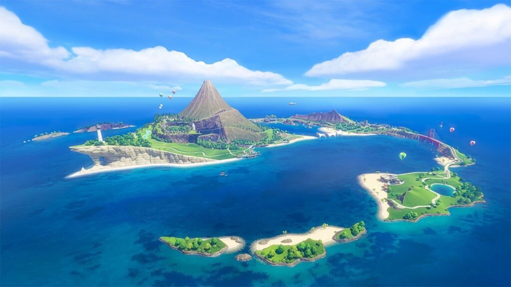 Aerial view of a tropical island cluster with a central volcano, green hills, white beaches and blue ocean. Paragliders float above the land.