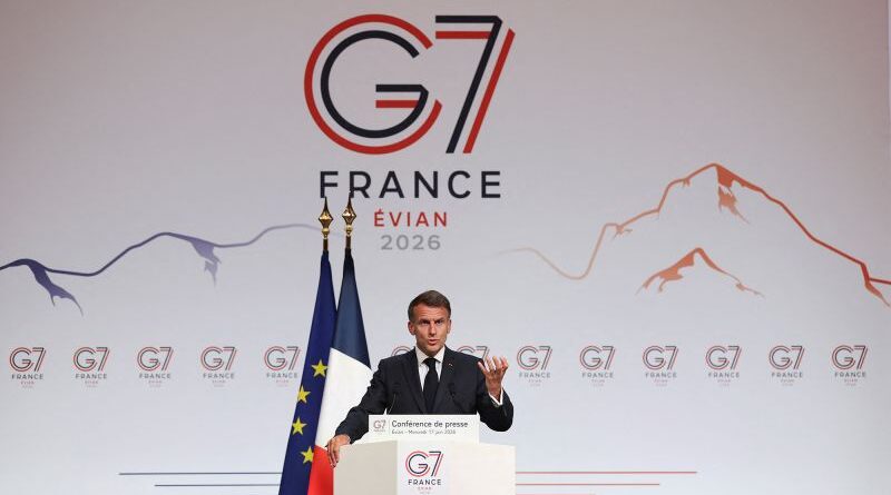 Man in a suit giving a press conference at the G7 France Evian 2026 stage, with EU and French flags behind him.