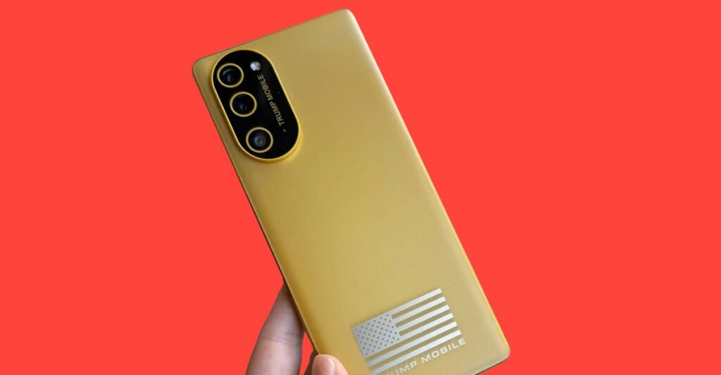 Gold smartphone with a tri-camera back held against a red background; features a silver American flag decal and 'TRUMP MOBILE' branding.