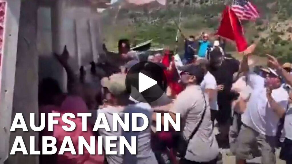 Crowd of protesters gathered outdoors, some waving flags, with bold overlay text reading 'AUFSTAND IN ALBANIEN' (news thumbnail).