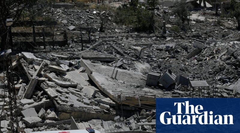 Rubble and collapsed buildings at a disaster site with debris strewn across the area; The Guardian watermark appears in the bottom-right corner.