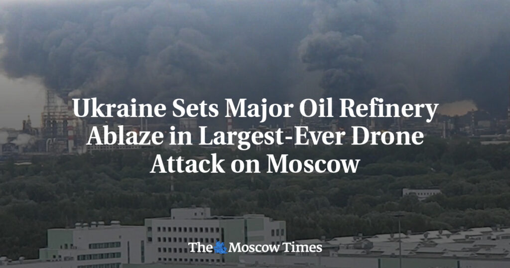 Headline reads 'Ukraine Sets Major Oil Refinery Ablaze in Largest-Ever Drone Attack on Moscow' over a burning oil refinery with dark smoke; The Moscow Times logo at bottom.