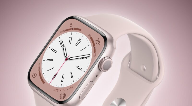 Close-up of a pink smartwatch on a white strap, angled to show the watch face and side crown against a soft pink background.