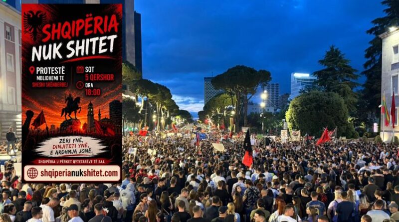 Huge protest crowd filling a city street at dusk, with a large red poster on the left that says 'Shqiperia Nuk Shtet'.