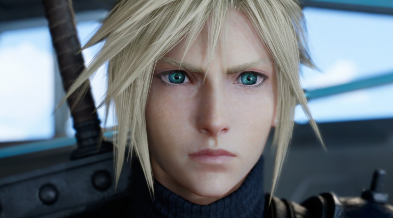 Close-up of a young man with spiky blond hair and bright blue-green eyes, wearing a dark high-neck outfit.