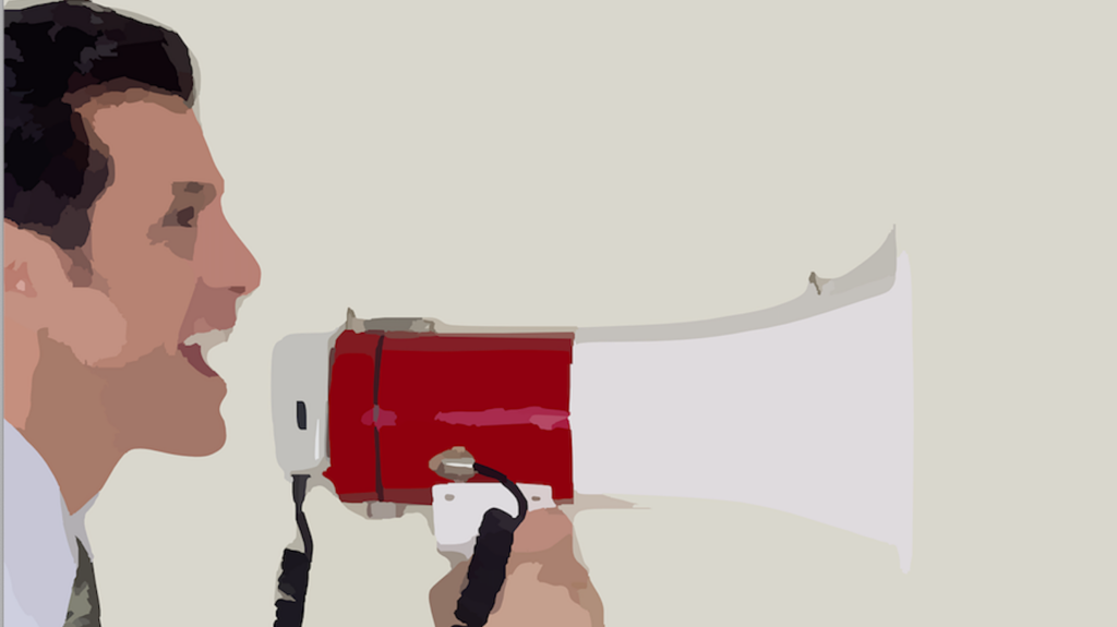Man in profile speaking into a red megaphone to amplify his voice.