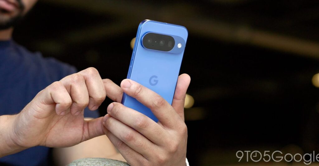 Person holding a blue Google Pixel smartphone, showing the large horizontal camera bar on the back.