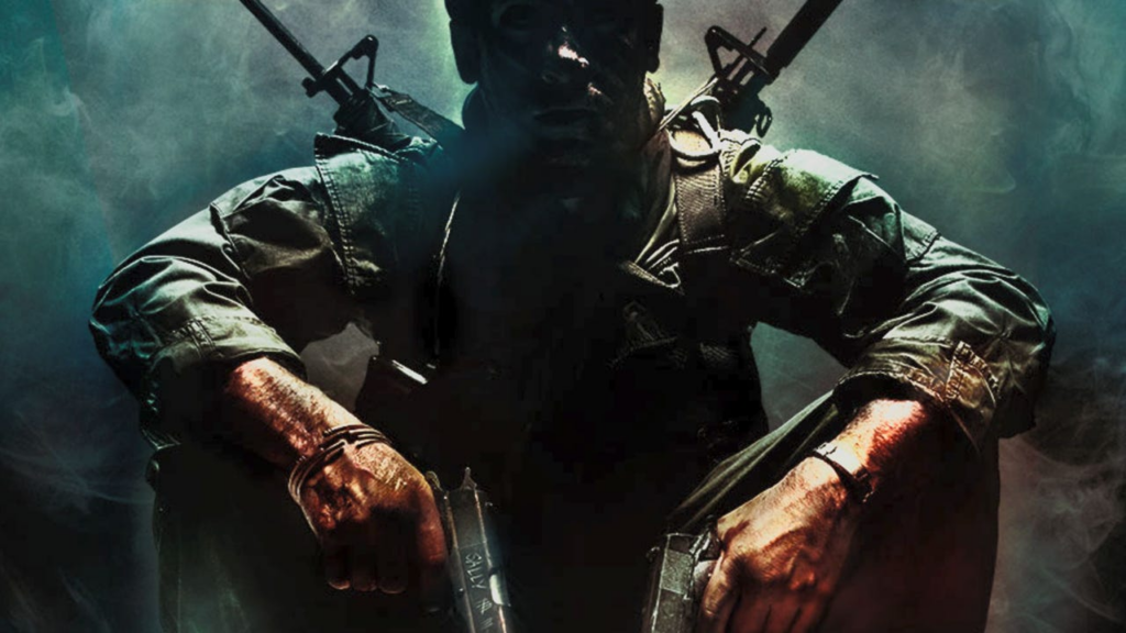 Soldier in tactical gear crouches with rifles and pistols, smoke-filled battlefield backdrop behind him.