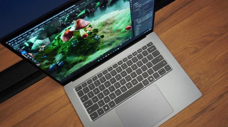 Open silver laptop on a wooden desk with a vibrant underwater coral reef image on the screen—likely a photo or editing workspace.