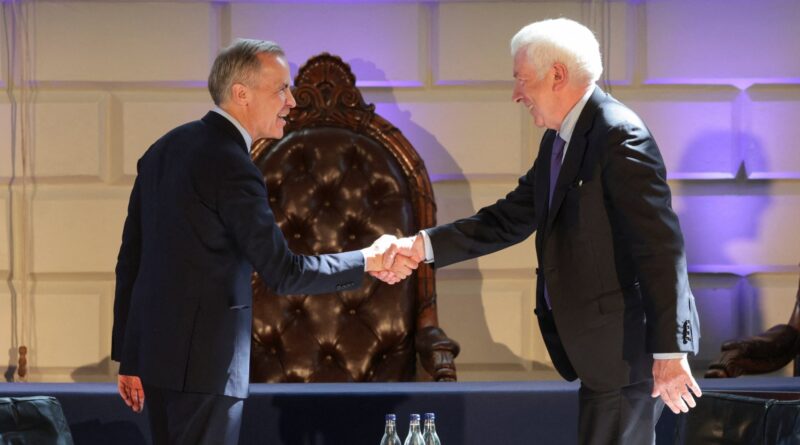 Two men in dark suits shake hands on a formal stage with a carved throne behind them.