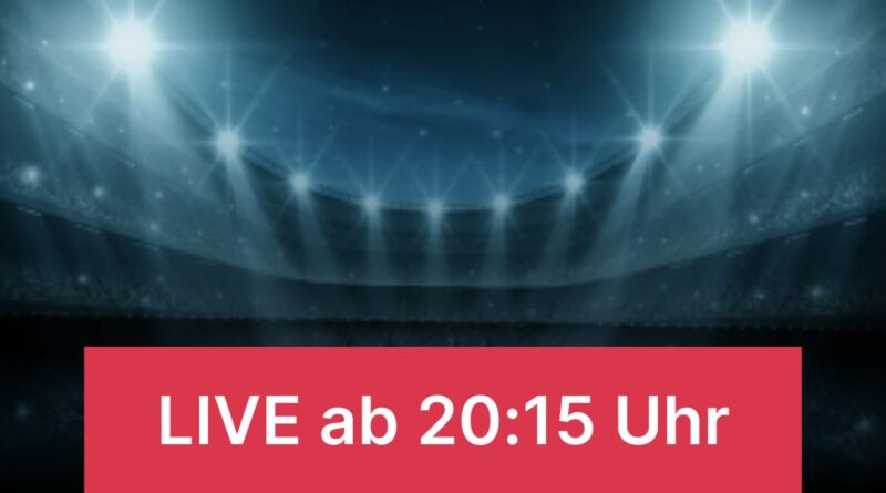 Stadium with bright blue floodlights and a red banner that says 'LIVE ab 20:15 Uhr'.