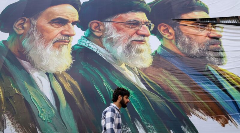 Man with a beard walks past a large colorful mural of three bearded men in religious attire.