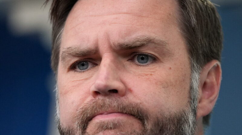 Close-up portrait of a middle-aged man with blue eyes and a trimmed beard, looking contemplative.