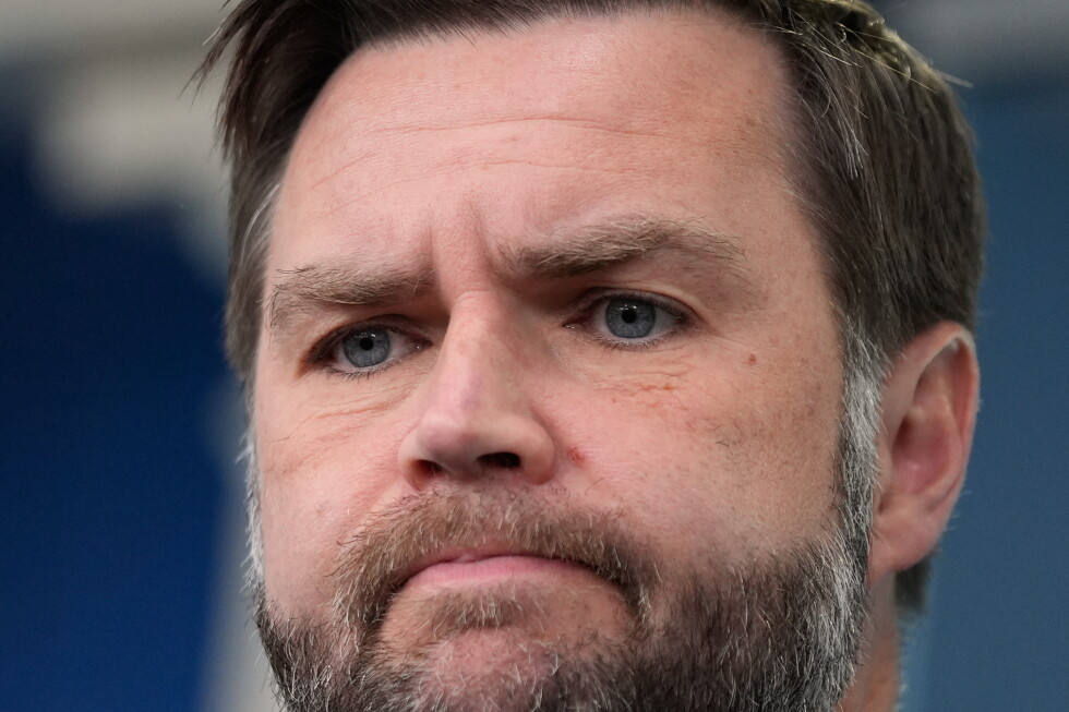 Close-up portrait of a middle-aged man with blue eyes and a trimmed beard, looking contemplative.