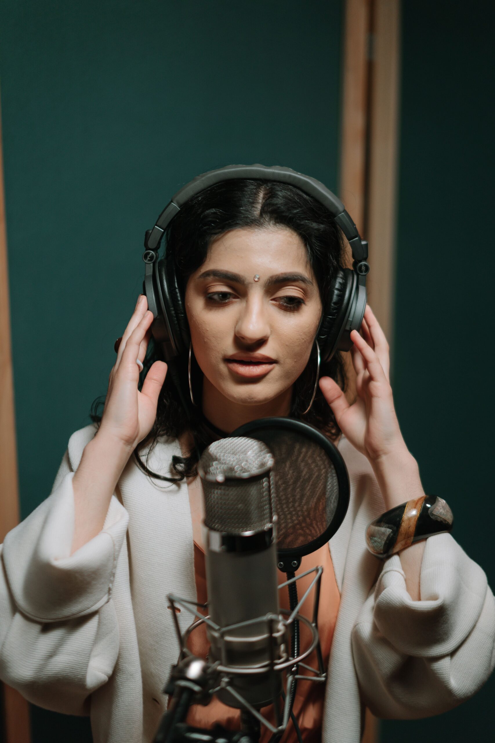 Këngëtare duke regjistruar muzikë në një studio profesionale