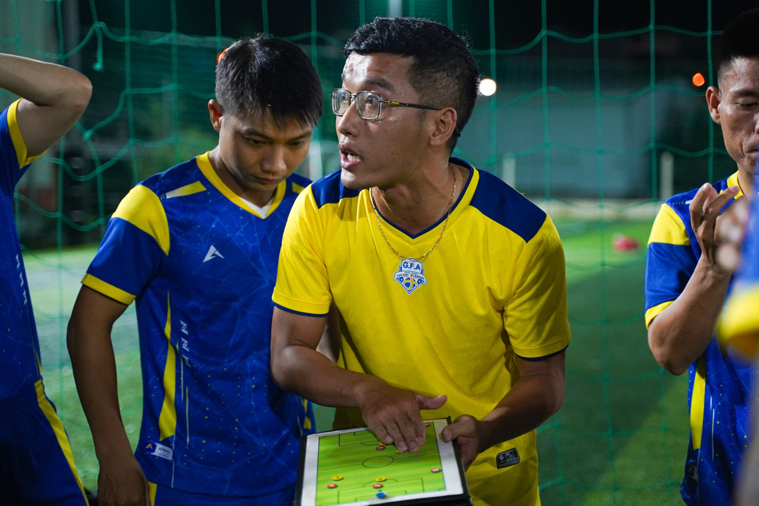 Trajner futbolli duke shpjeguar taktikat e lojës me tablet